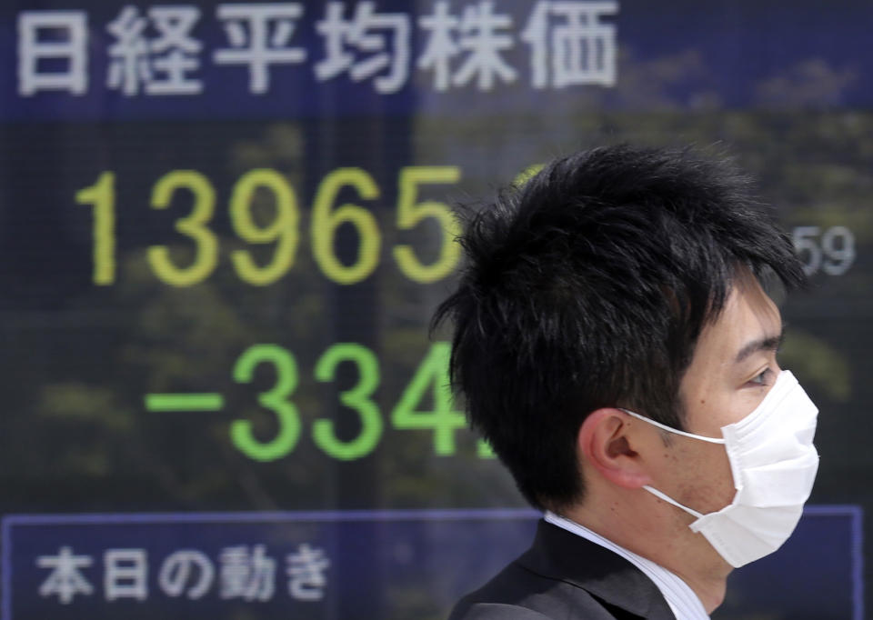 A man walks by an electronic stock board of a securities firm in Tokyo showing Japan's Nikkei 225 stock average that dropped 334 points to 13,965 Friday morning, April 11, 2014. (AP Photo/Koji Sasahara)
