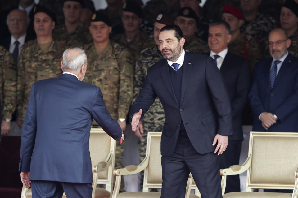 Former Prime Minister Saad Hariri, right, shakes hands with Lebanese Parliament Speaker Nabih Berri as attend a military parade to mark the 76th anniversary of Lebanon's independence from France at the Lebanese Defense Ministry, in Yarzeh near Beirut, Lebanon, Friday, Nov. 22, 2019. Lebanon's top politicians Friday, attended a military parade on the country's 76th Independence Day, appearing for the first time since the government resigned amid nationwide protests now in their second month. (AP Photo/Hassan Ammar)