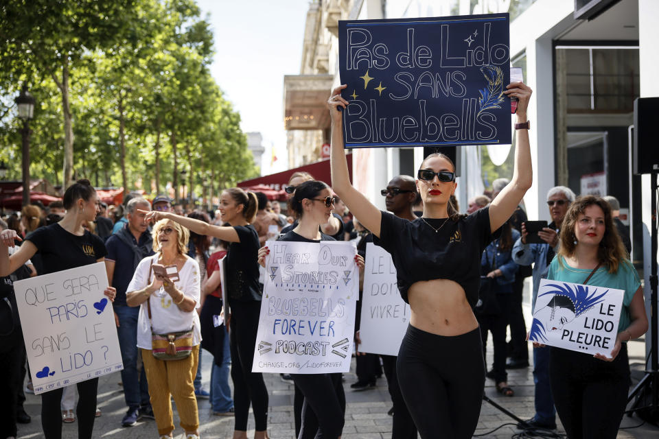 Lido cabaret dancers, other employees and union activists demonstrate to try to save their jobs and the history of the cabaret, known for its dinner theater and its "Bluebell Girls" revue, Saturday, May 28, 2022 on the Champs Elysee avenue in Paris. Amid financial troubles and changing times, the venue's new corporate owner is ditching most of the Lido's staff and its high-kicking, high-glamour dance shows — which date back decades and inspired copycats from Las Vegas to Beirut — in favor of more modest musical revues. (AP Photo/Thomas Padilla)