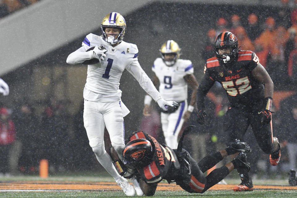 Washington wide receiver Rome Odunze (1) is brought down by Oregon State linebacker Easton Mascarenas-Arnold (5) during the first half of an NCAA college football game Saturday, Nov. 18, 2023, in Corvallis, Ore. (AP Photo/Mark Ylen)
