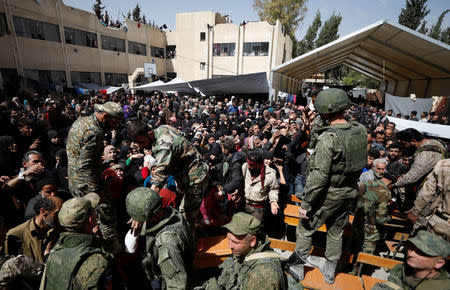 People who fled eastern Ghouta gather as they receive aid from Russian forces at a shelter in Adra, near Damascus, Syria, March 20, 2018. REUTERS/Omar Sanadiki