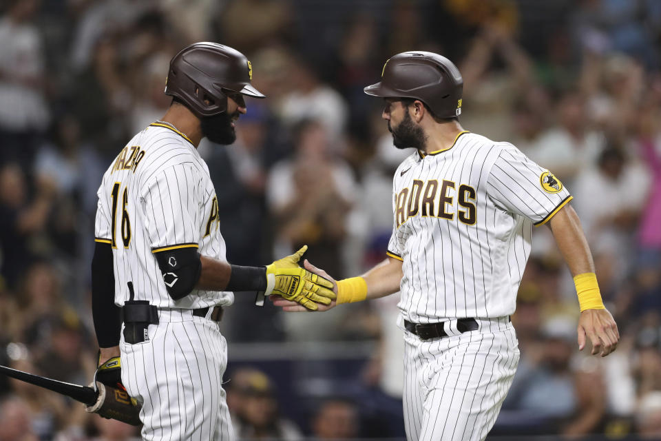 San Diego Padres' Eric Hosmer, right, is congratulated by Nomar Mazara after scoring against the Philadelphia Phillies during the sixth inning of a baseball game Friday, June 24, 2022, in San Diego. (AP Photo/Derrick Tuskan)