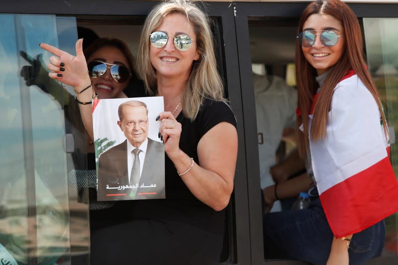 A supporter of Lebanon's President Michel Aoun hold his poster during a rally in Baabda near Beirut