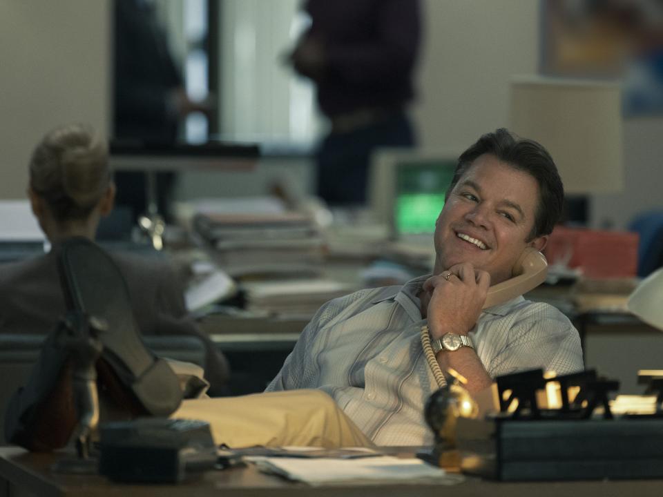 Matt Damon with his legs up at a desk while on the phone