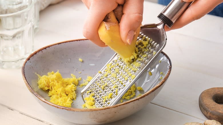 grating ginger into bowl