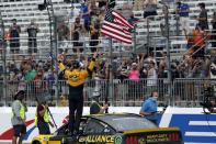 Driver Brad Keselowski celebrates with the American flag after winning during a NASCAR Cup Series auto race, Sunday, Aug. 2, 2020, at the New Hampshire Motor Speedway in Loudon, N.H. (AP Photo/Charles Krupa)
