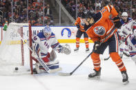 New York Rangers goalie Alexandar Georgiev (40) makes a save against Edmonton Oilers' Jesse Puljujarvi (13) during second-period NHL hockey game action in Edmonton, Alberta, Friday, Nov. 5, 2021. (Jason Franson/The Canadian Press via AP)