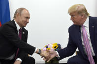 FILE - In this June 28, 2019, file photo, President Donald Trump, right, shakes hands with Russian President Vladimir Putin, left, during a bilateral meeting on the sidelines of the G-20 summit in Osaka, Japan. Intelligence officials say Russia is interfering with the 2020 election to try to help Trump get reelected, The New York Times reported Thursday, Feb. 20, 2020. (AP Photo/Susan Walsh, File)