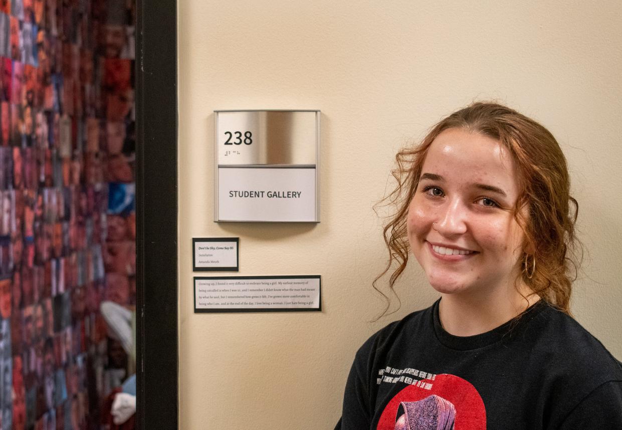 Senior Amanda Meuth outside of her independent project "Don't Be Shy, Come Say Hi" in the Arts Center at the University of Southern Indiana. In the student gallery, she shares her project highlights the online dating experience that many go through with older men.