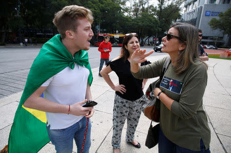 A supporter (L) of presidential candidate Bolsonaro argue with Brazilians living in Mexico during a demonstration against Brazil's presidential candidate Jair Bolsonaro ahead of the country's elections, at the Angel of Independence monument in Mexico City, Mexico September 29, 2018. REUTERS/Gustavo Graf