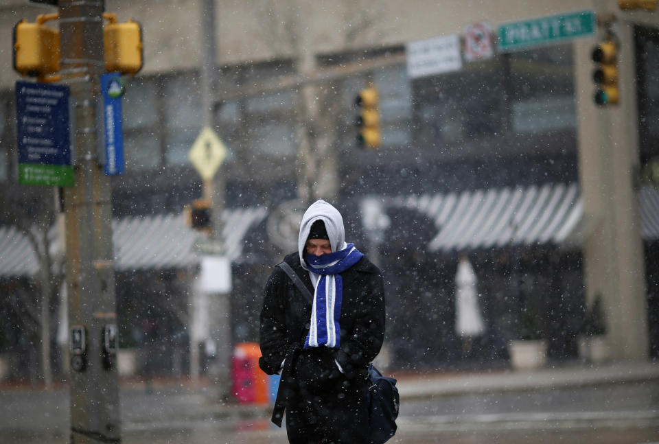 A man stays bundled up as he walks through a light snowfall in Baltimore, Tuesday, March 25, 2014. An unwelcome nor'easter is expected in the region just days after the start of spring. (AP Photo/Patrick Semansky)