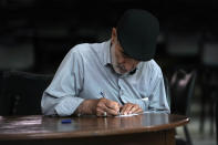An Iranian man fills out his ballot for the presidential runoff election at a polling station in Tehran, Iran, Friday, July 5, 2024. Iranians are voting in a runoff election to replace the late President Ebrahim Raisi, who was killed in a May helicopter crash in the country’s northwest along with the foreign minister and several other officials. (AP Photo/Vahid Salemi)