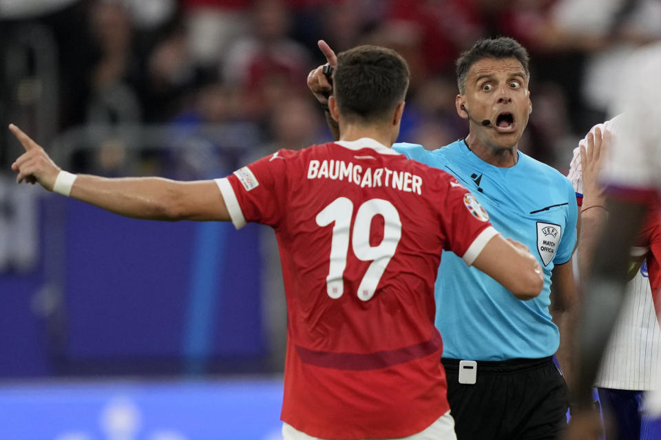 Referee Jesus Gil Manzano of Spain, right, talks to Austria's Christoph Baumgartner during a Group D match between Austria and France at the Euro 2024 soccer tournament in Duesseldorf, Germany, Monday, June 17, 2024. (AP Photo/Martin Meissner)