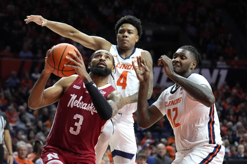 Nebraska's Brice Williams (3) drives to the basket past Illinois' Justin Harmon (4) and Dain Dainja during second half of an NCAA college basketball game Sunday, Feb. 4, 2024, in Champaign, Ill. (AP Photo/Charles Rex Arbogast)