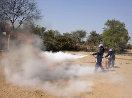 Students douse a fire during a training session at a fire and safety college in Sikar district in Rajasthan February 9, 2015. REUTERS/Stringer