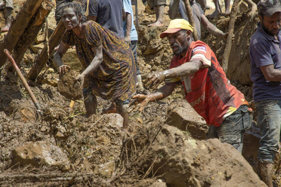 In this photo released by UNDP Papua New Guinea, villagers search through a landslide in Yambali village, in the Highlands of Papua New Guinea, Monday, May 27, 2024. Authorities fear a second landslide and a disease outbreak are looming at the scene of Papua New Guinea's recent mass-casualty disaster because of water streams trapped beneath tons of debris and decaying corpses seeping downhill following the May 24 landslide. (Juho Valta/UNDP Papua New Guinea via AP)