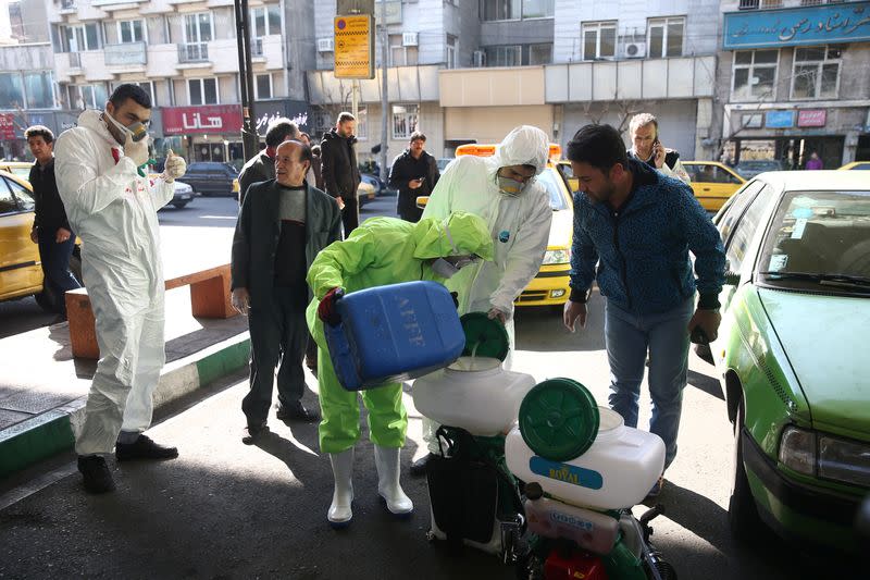 Members of the medical team wear protective face masks, following the coronavirus outbreak, as they prepare disinfectant liquid to sanitise public places in Tehran