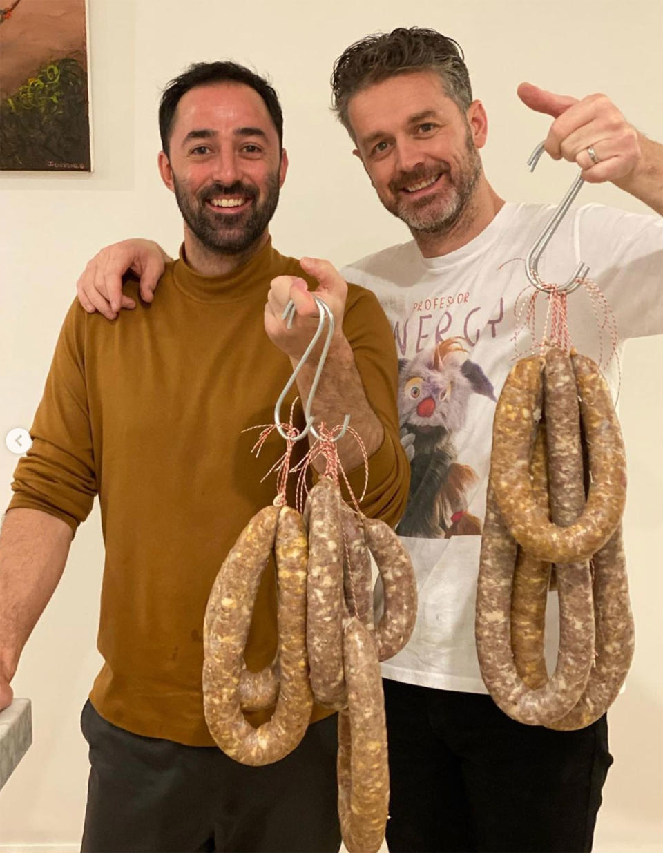 Andy Allen and Jock Zonfrillo holding up sausages