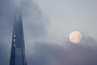 A full moon passes by the Shard skyscraper in London on Thursday Dec. 31, 2020. (AP Photo/Tony Hicks)