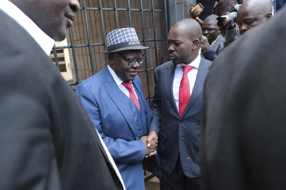 Zimbabweas main opposition leader Nelson Chamisa, center right, greets prominent politician Tendai Biti upon his release at the magistrates courts in Harare, Monday, Feb, 18, 2019. A Zimbabwean court has convicted prominent opposition politician Tendai Biti for announcing that his party's leader won disputed elections held in July. Biti was on trial for "unofficial and false declaration of results." (AP Photo/Tsvangirayi Mukwazhi)