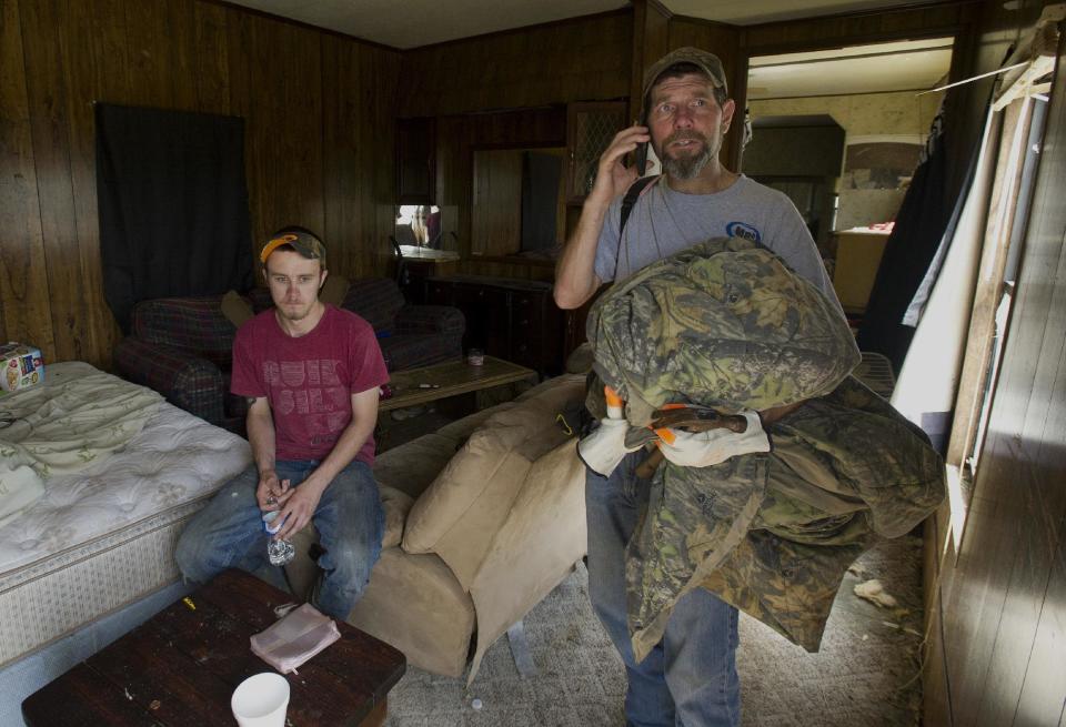 Henry Schwan, right, helps Casey Spain recover items from his home at the Billy Barb trailer park in Coxey, Ala. A dangerous storm system that spawned a chain of deadly tornadoes killed dozens from the Midwest to the Deep South. (AP Photo/The Decatur Daily, Brennen Smith)