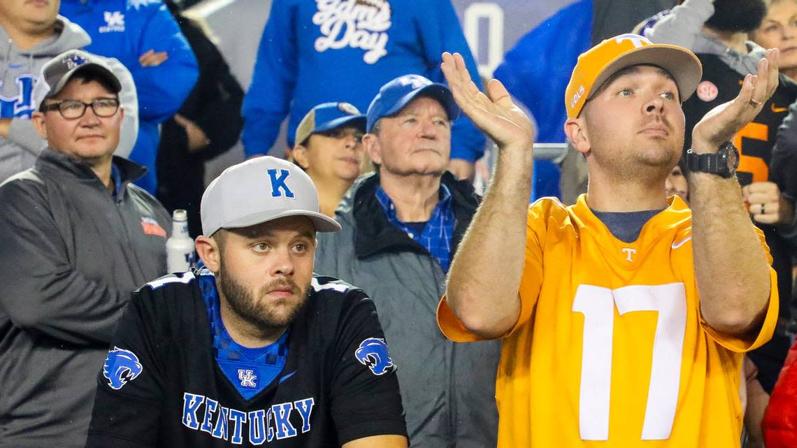 A Kentucky fan is dejected while a Tennessee fan cheers in the stands during the second half at Kroger Field.