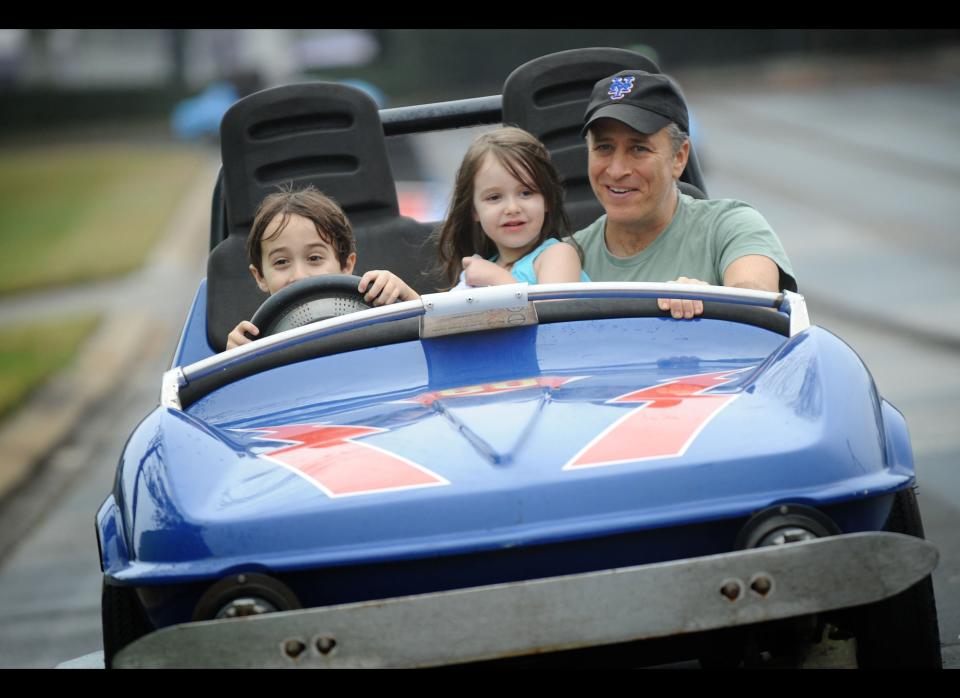 Jon Stewart takes a ride on the Tomorrowland Indy Speedway with his children Nate (left, age 6) and Maggie (center, age 5) at the Magic Kingdom theme park on February 4, 2011 in Lake Buena Vista, Florida.  The February 4 visit took place on Maggie's 5th birthday, and Stewart and his family celebrated the occasion with friends at the Walt Disney World theme park.      (Photo by David Roark/Disney via Getty Images)