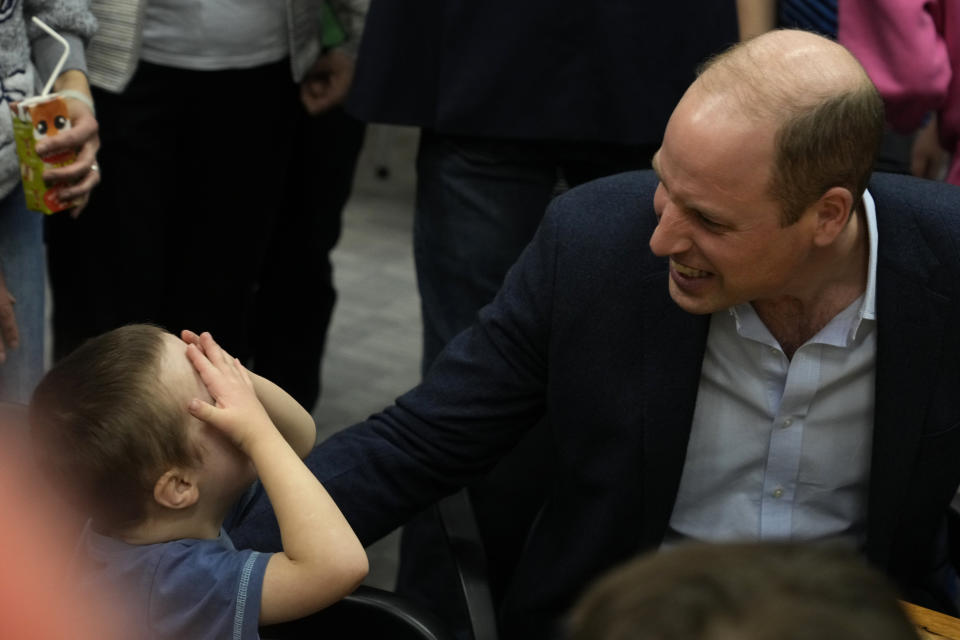 Britain's Prince William smiles with a young boy as he visits an accommodation centre, for Ukrainians who fled the war, in Warsaw, Poland, Wednesday, March 22, 2023. (AP Photo/Czarek Sokolowski)