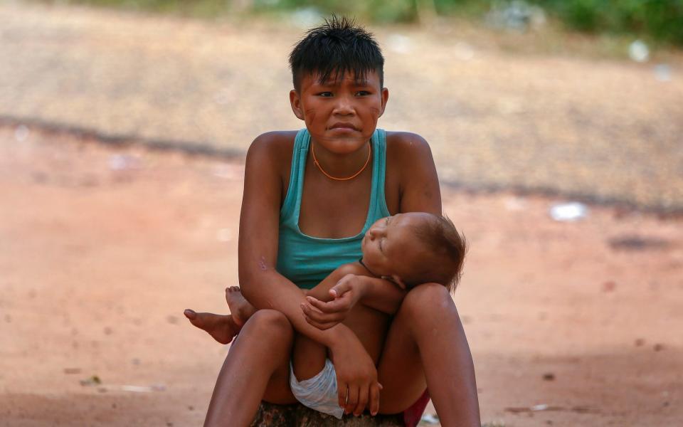 A Yanomami woman with her child in Boa Vista. The indigenous people have suffered the devastating effects of illegal mining in the region - Edmar Barros/AP