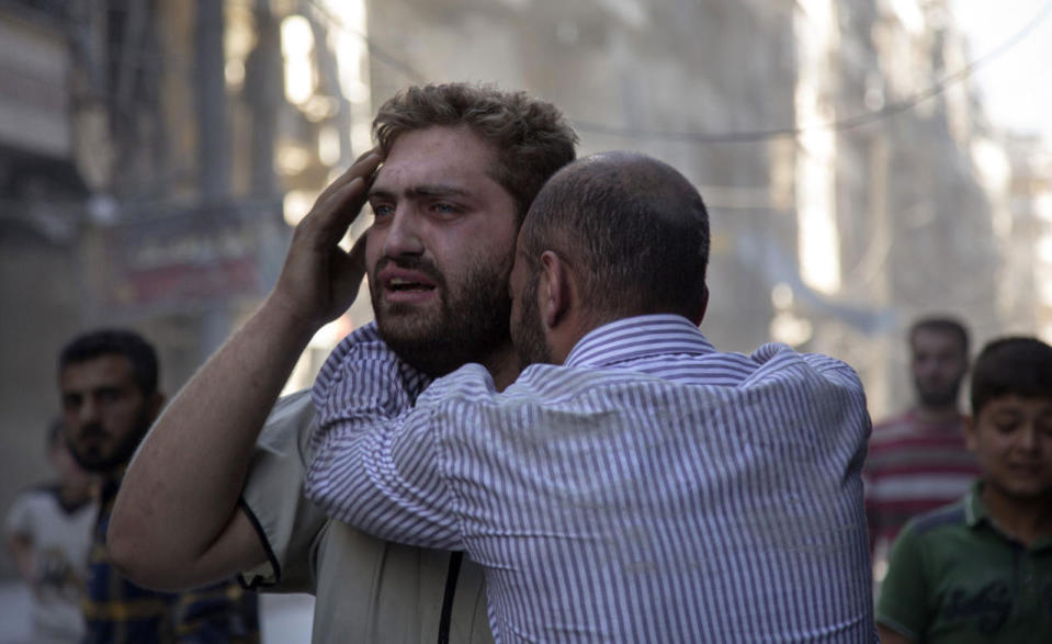 <p>Syrians react as the bodies of children are pulled from the rubble of a budling following government forces air strikes in the rebel held neighbourhood of Al-Shaar in Aleppo on September 27, 2016. Syria’s army took control of a rebel-held district in central Aleppo, after days of heavy air strikes that have killed dozens and sparked allegations of war crimes. (Karam Al-Masri/AFP/Getty Images)</p>