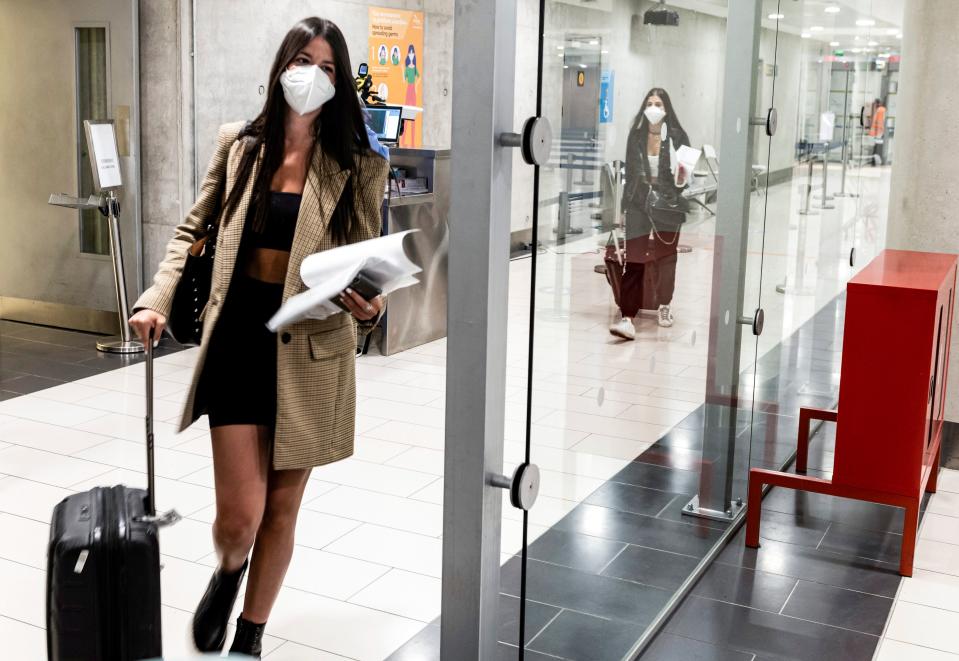 Mask-clad travellers walk with their luggage towards passport control upon arrival at Larnaca International Airport on June 9, 2020. - Cyprus opened back up for international tourism on June 9, with airports welcoming visitors after an almost three-month shutdown due to the COVID-19 coronavirus pandemic, with a bold plan to cover health care costs for visitors. (Photo by Iakovos HATZISTAVROU / AFP) (Photo by IAKOVOS HATZISTAVROU/AFP via Getty Images)