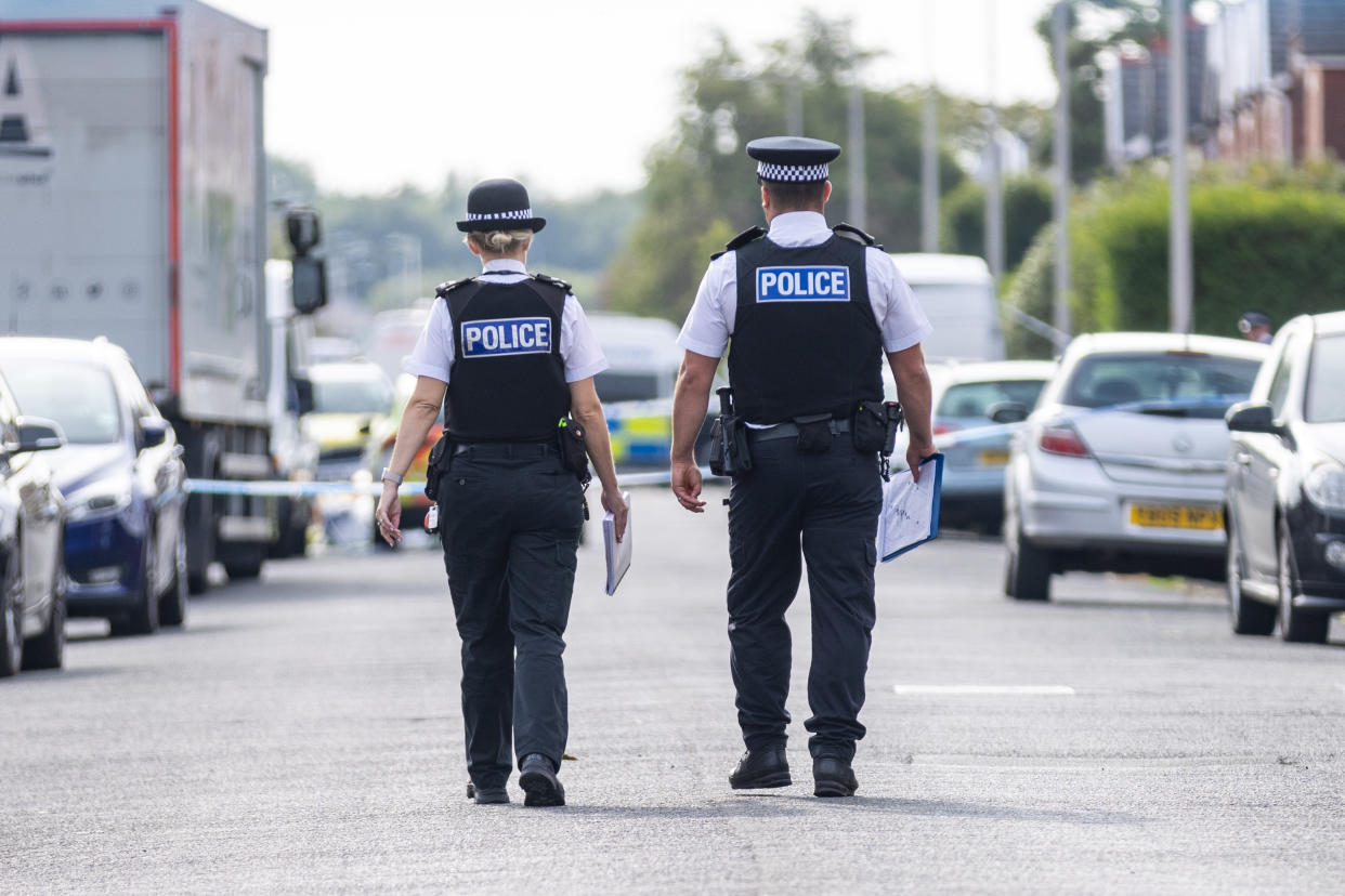 Police officers near the scene in Hart Street, Southport, where two children died and nine were injured in a 