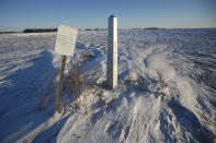 A border marker, between the United States and Canada is shown just outside of Emerson, Manitoba, on Thursday, Jan. 20, 2022. A Florida man was charged Thursday with human smuggling after the bodies of four people, including a baby and a teen, were found in Canada near the U.S. border, in what authorities believe was a failed crossing attempt during a freezing blizzard. The bodies were found Wednesday in the province of Manitoba just meters (yards) from the U.S. border near the community of Emerson. (John Woods/The Canadian Press via AP)