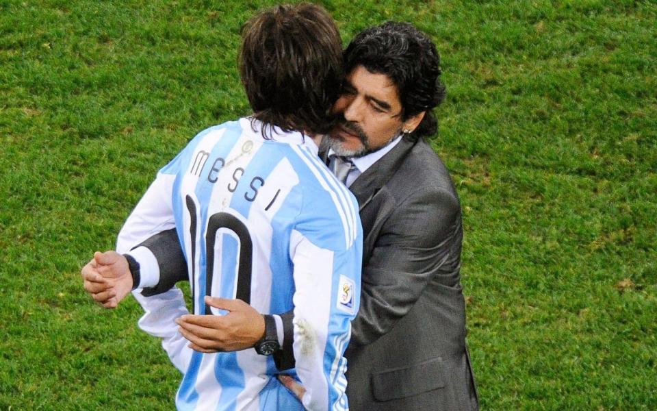 Argentinian national soccer team head coach Diego Maradona (R) embraces Lionel Messi (L) after the FIFA World Cup 2010  - Shutterstock