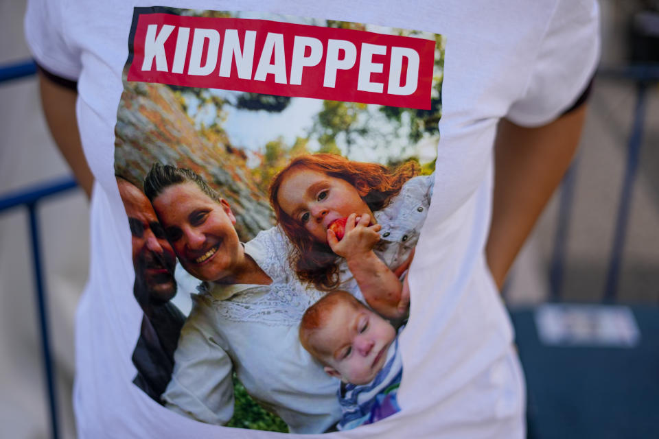 Ofri Bibas Levy wears a shirt with her brother, sister-in-law and their two children, age 4 and 10 months held captive in Gaza, in Tel Aviv, Israel, Tuesday, Nov. 21, 2023. Ofri Bibas Levy has been haunted by nightmares since Oct. 7, when her brother, sister-in-law and their two children, age 4 and 10 months, were snatched by Hamas militants from their homes and dragged into the Gaza Strip. The cease-fire deal between Israel and Hamas which gets underway Friday will bring relief to dozens of families. But with militants having abducted 240 people, many families will be left to endure the torment. (AP Photo/Ariel Schalit)