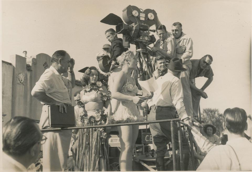 During the 1951 filming of a parade sequence in downtown Sarasota for the movie “The Greatest Show on Earth,” actresses Gloria Grahame, second from left, and Betty Hutton, are seen with director Cecil B. DeMille, who’s wearing a fedora and with his back to the camera.