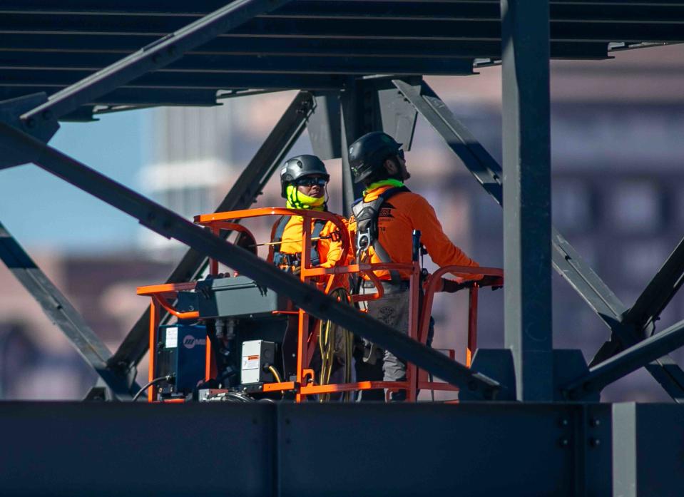 Workers use a lift to help erect a multilevel structure at the Royal Poinciana Playhouse construction site on April 5.