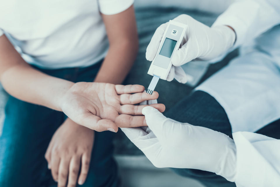 Doctor Taking Blood Sample from Boy's Finger. Diabetes Concept. Sugar in Blood. Healthcare Concept. Young Man in Uniform. White Coat. Medical Equipment. Boy in Clinic. Glucometer in Hand.