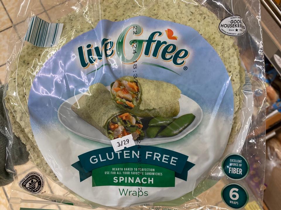 Hand holding clear and blue bag of liveGfree wraps at Aldi