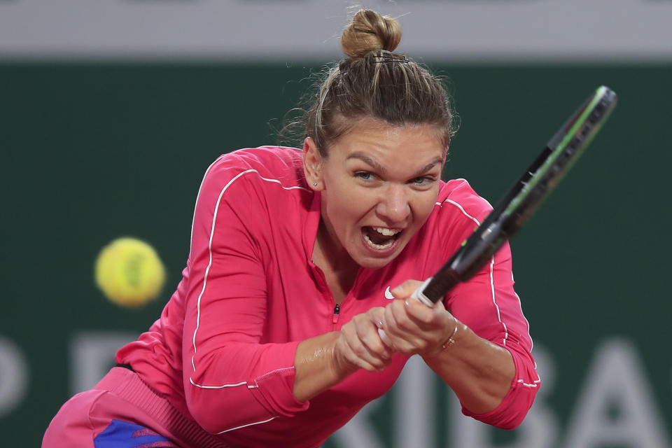 FILE - In this file photo dated Sunday, Oct. 4, 2020, Romania's Simona Halep plays a shot against Poland's Iga Swiatek in the fourth round match of the French Open tennis tournament at the Roland Garros stadium in Paris, France. Simona Halep said Saturday Oct. 31, 2020, that she has tested positive for COVID-19 coronavirus. (AP Photo/Michel Euler, FILE)