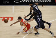 Atlanta Hawks Trae Young, left, drives the ball away from Orlando Magic guard Cole Anthony (50) and Gary Harris (14) during the first half of an NBA basketball game Tuesday, April 20, 2021, in Atlanta. (AP Photo/Ben Margot)