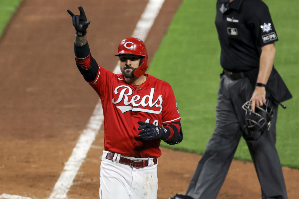 Cincinnati Reds' Nick Castellanos reacts to hitting a solo home run during the sixth inning of a baseball game against the Cleveland Indians in Cincinnati, Friday, April 16, 2021. (AP Photo/Aaron Doster)