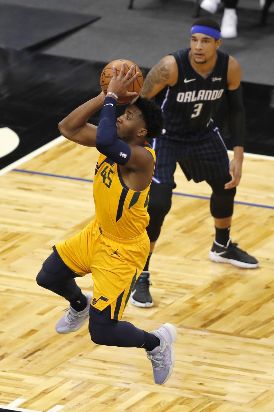 Utah Jazz guard Donovan Mitchell (45) drives to the basket past Orlando Magic forward Chuma Okeke (3) in the first quarter during an NBA basketball game, Saturday, Feb. 27, 2021, in Orlando, Fla. (AP Photo/Joe Skipper)