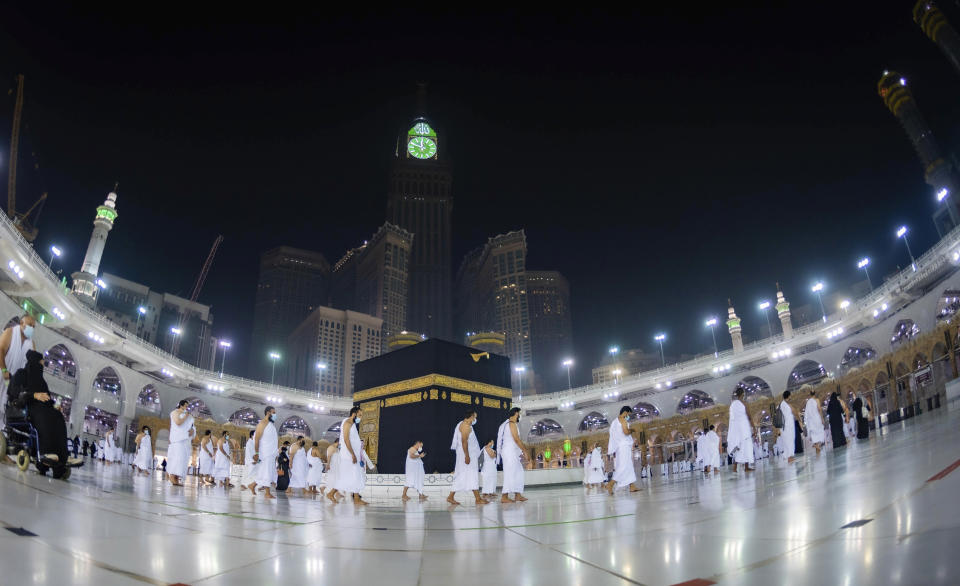 CLARIFIES THAT THE UMRAH PILGRIMAGE CAN BE UNDERTAKEN AT ANY TIME OF THE YEAR -- In this photo released by Saudi Ministry of Hajj and Umrah, Muslims practice social distancing while praying around the Kaaba, the cubic building at the Grand Mosque during the first day umrah pilgrimages were allowed to restart, in the Muslim holy city of Mecca, Saudi Arabia, Sunday, Oct. 4, 2020. The umrah pilgrimage, or smaller pilgrimage, can be undertaken at any time of the year. A very small, limited number of people donning the white terrycloth garment symbolic of the Muslim pilgrimage circled Islam's holiest site in Mecca on Sunday after Saudi Arabia lifted coronavirus restrictions that had been in place for months. (Saudi Ministry of Hajj and Umrah via AP)