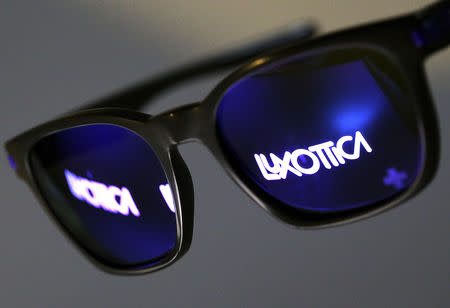 FILE PHOTO: The Luxottica name is reflected in a pair of sunglasses in this photo illustration taken in Rome February 4, 2016. REUTERS/Alessandro Bianchi/File Photo