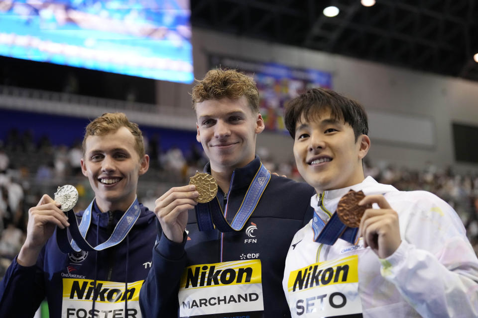 Gold medallist Leon Marchand of France, center, is with by silver medallist Carson Foster of the United States, and bronze medallist Daiya Seto of Japan pose with their medals after winning Men's 400m Individual Medley finals at the World Swimming Championships in Fukuoka, Japan, Sunday, July 23, 2023. (AP Photo/Lee Jin-man)