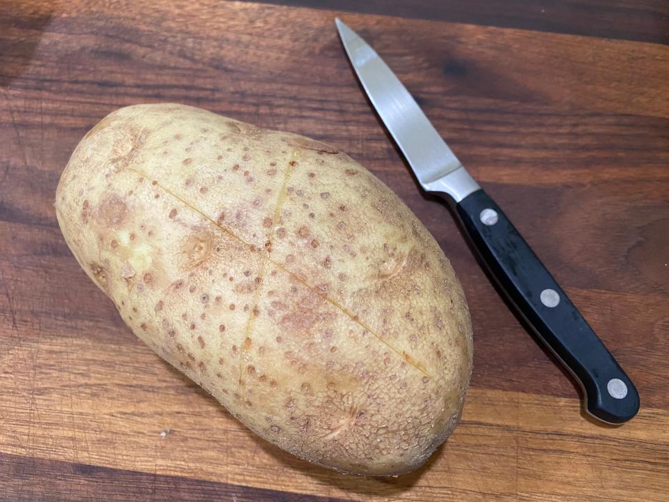 potato on cutting board beside small knife