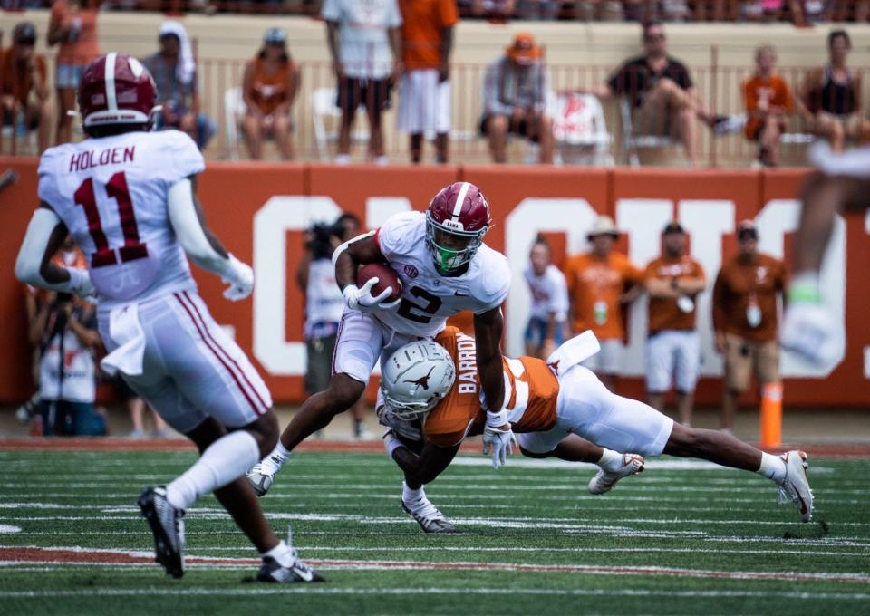 Texas defensive back Jahdae Barron tackles Alabama running back Jase McClellan during the first half of last year's game in Austin. The Crimson Tide escaped with a 20-19 win and are favored by seven points this Saturday.