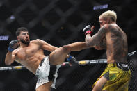 Arman Tsarukyan, left, kicks Charles Oliveira during a UFC 300 mixed martial arts lightweight bout Saturday, April 13, 2024, in Las Vegas. (Ellen Schmidt/Las Vegas Review-Journal via AP)