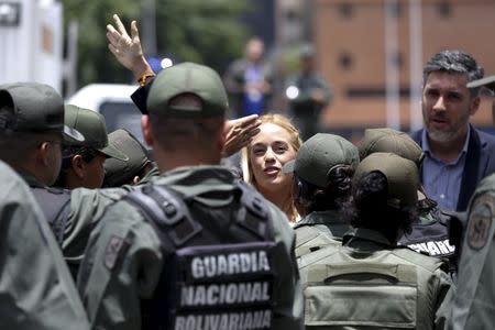 Lilian Tintori (C), wife of jailed opposition leader Leopoldo Lopez waves to supporters next to Venezuelan National Guards as she arrives at the courthouse to attend her husband's trial in Caracas September 10, 2015. REUTERS/Carlos Garcia Rawlins